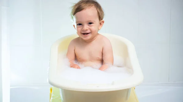Retrato de niño risueño alegre bañándose con espuma y suds — Foto de Stock