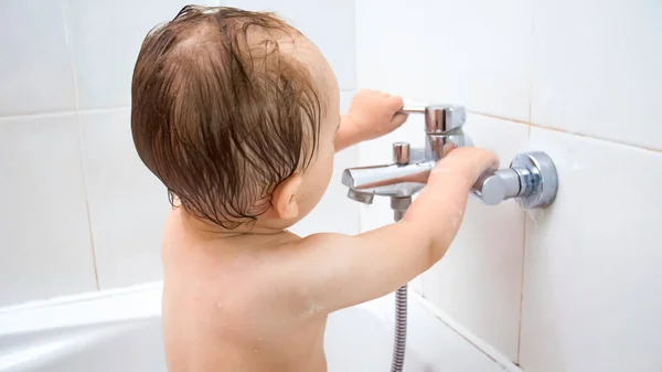 Banyoda çamaşır süre musluk suyu açmaya çalışırken şirin yürümeye başlayan çocuk — Stok fotoğraf