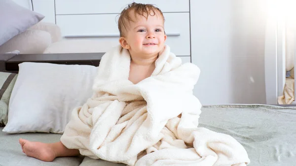 Porträtt av söt leende barn pojke sitter under handduk efter badet — Stockfoto