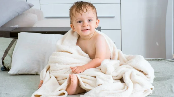 Menino bonito criança com cabelo molhado coberto de toalha após o banho — Fotografia de Stock