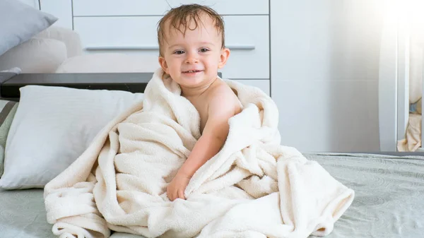 Söt liten knatte pojke placering på sängen efter bad — Stockfoto