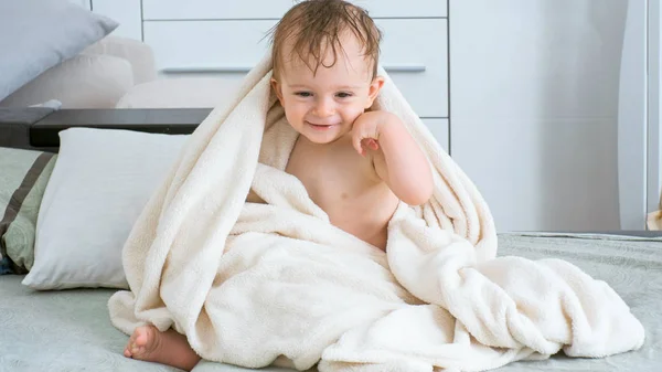 Happy cheerful toddler boy covered in white towel after bathing — Stock Photo, Image