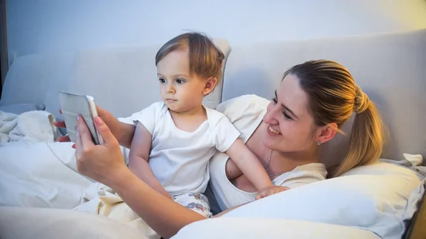 Retrato de mãe com seu filho criança assistindo desenhos animados antes de ir dormir — Fotografia de Stock
