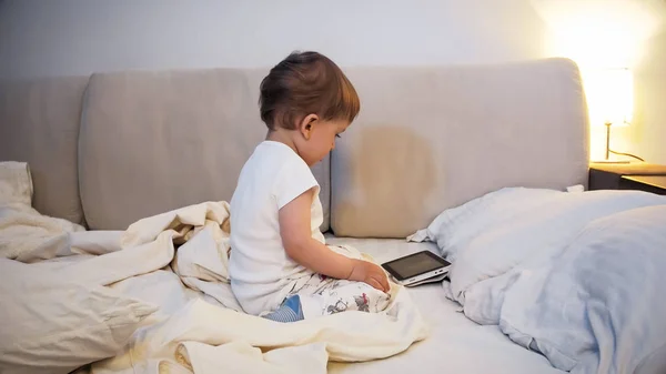 2 years old toddler boy watching cartoons on digital tablet before going to sleep — Stock Photo, Image