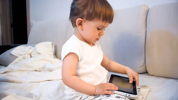 Портрет чарівного маленького хлопчика в піжамі, що тримає цифровий планшет — стокове фото