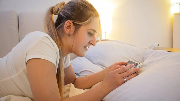 Detailní portrét krásné mladé ženy s digitálním tabletu, ležící v posteli — Stock fotografie