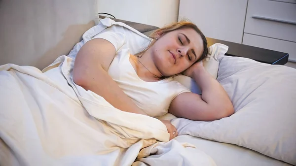 ベッドで寝ている若いブルネットの女性の肖像画 — ストック写真