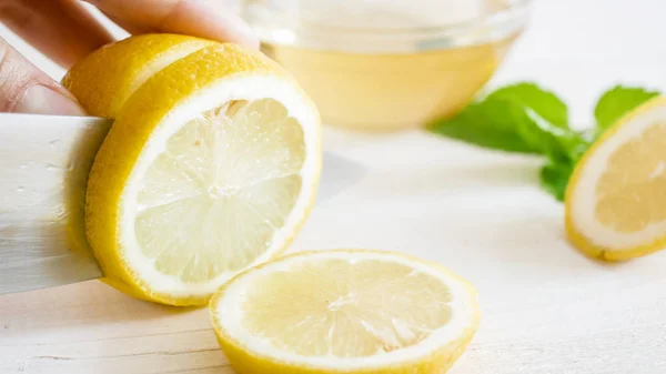 화이트 나무 보드에 여성 손 절단 신선한 레몬의 근접 촬영 사진 — 스톡 사진
