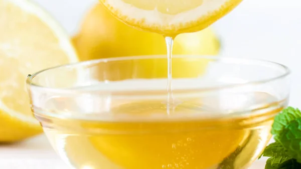 Macro imagem de mel de abelha natural pingando de fatia de limão — Fotografia de Stock
