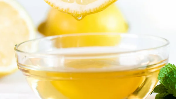 Zbliżenie obraz soczysty cytryny nad miska z bee honey — Zdjęcie stockowe
