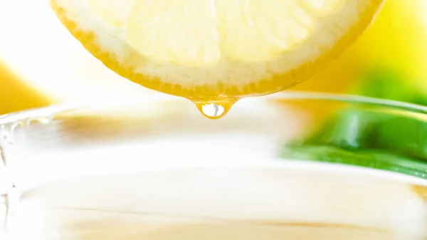 Макроизображение капли лимонного сока, падающей в чашку чая — стоковое фото