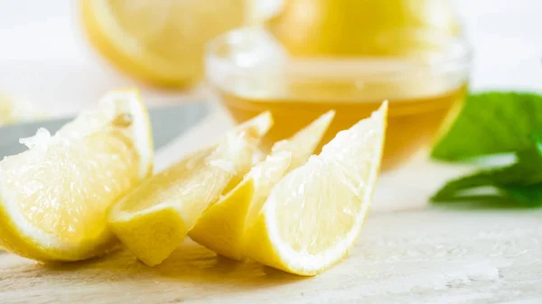カット新鮮なレモン、ミントの葉、蜂蜜の瓶のマクロ画像 — ストック写真