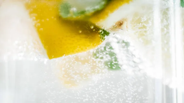 Makro snímek vzduchové bubliny plovoucí ve sklenici vychlazené limonády — Stock fotografie