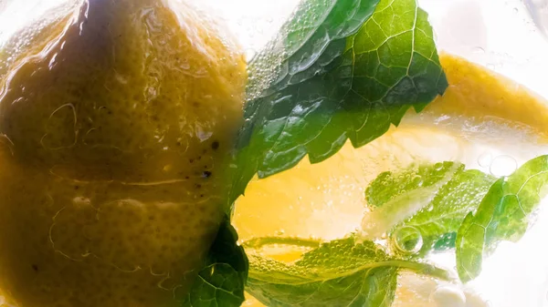 Gazlı su içinde makro görüntü limon ve nane yaprakları — Stok fotoğraf