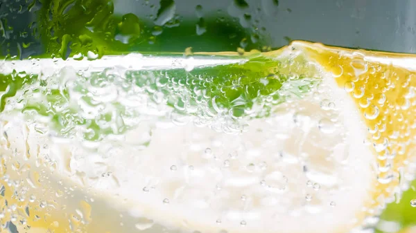 레몬 조각과 민트 잎에서 공기 방울의 유리를 통해 매크로 이미지 — 스톡 사진