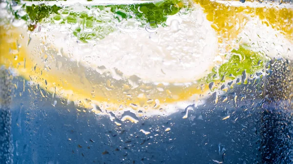Macro opname van water druppels druipen beneden glas koude limonade — Stockfoto