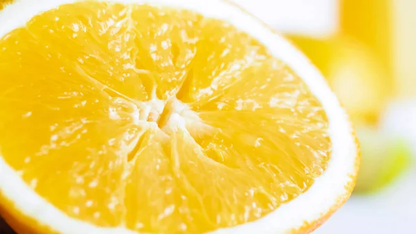 Imagen macro de la mitad naranja recién cortada sobre el dorso blanco — Foto de Stock