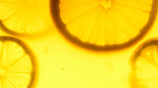 Imagem macro de limonada retroiluminada com fatias de laranja — Fotografia de Stock