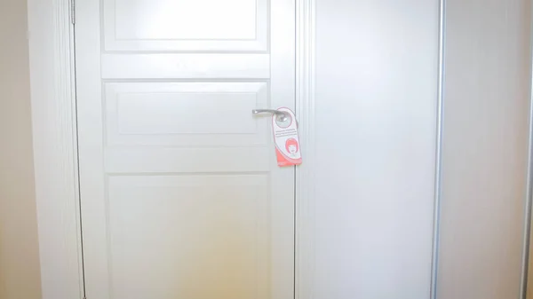 Closeup image of do not disturb sign hanging on door — Stock Photo, Image