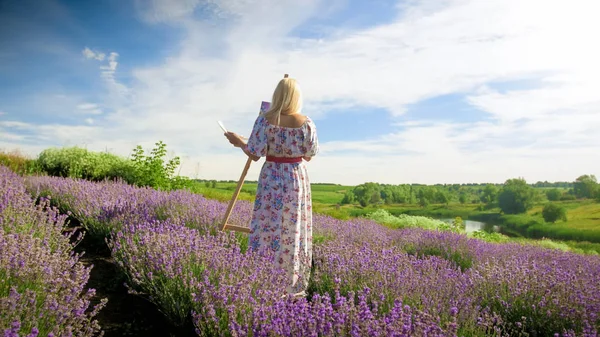 Rear view-beeld van vrouwelijke kunstenaar schilderij beeld van Lavendel veld — Stockfoto