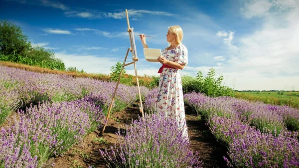 Hermosa mujer sonriente dibujo de campo de lavanda por la mañana — Foto de Stock