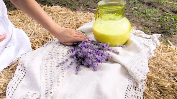 Closeup photo of young woman sitting on farm and holding bunch of lavender flowers — Stock Photo, Image