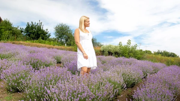 Mujer joven en vestido blanco posando en el campo de lavanda — Foto de Stock