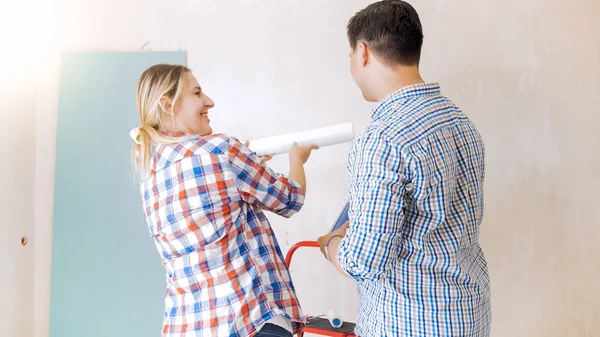 Jovem casal feliz escolhendo papéis de parede para renovação em casa — Fotografia de Stock