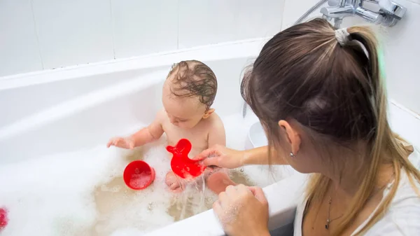Young mother playing with her toddler son washing in bath — Stock Photo, Image