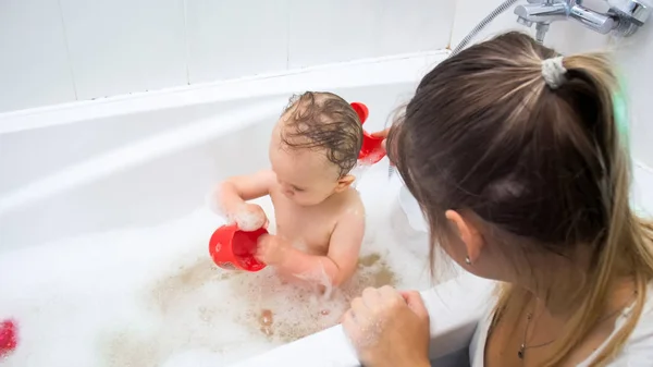 Young mother washing her toddler son in bath — Stock Photo, Image