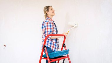 Güzel ve genç birbayan boyama duvarları boya silindiri ile portresi