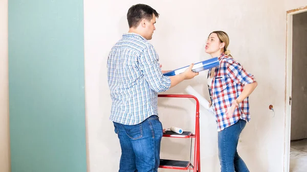 Молодая женщина кричит на своего мужа, делая ремонт в новом доме — стоковое фото