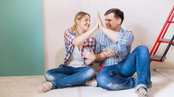 Glückliches junges Paar schenkt sich nach Renovierung zu Hause fünf — Stockfoto