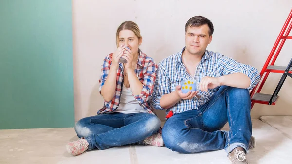 Jovem família fazendo coffee break depois de fazer renovação no novo apartamento — Fotografia de Stock