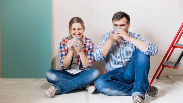 Glücklich lächelndes Ehepaar trinkt Kaffee in Haus im Bau — Stockfoto