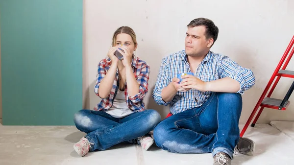 Junge Männer und Frauen ruhen sich aus und trinken Kaffee im renovierten Haus — Stockfoto