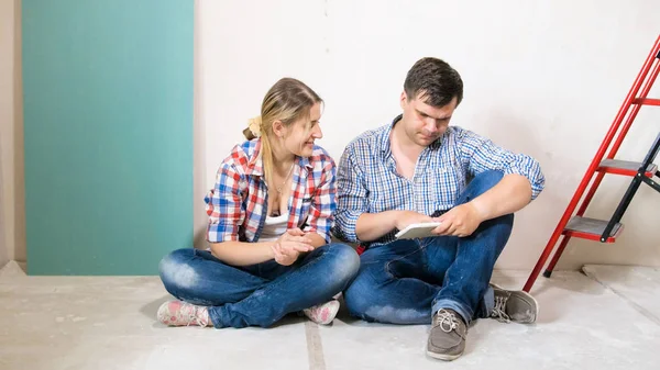 Ung man och kvinna som använder digitala tablett i hus under renovering — Stockfoto