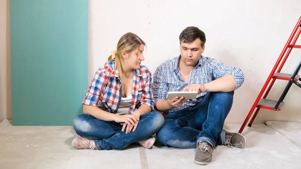 Junges Paar wählt Entwurf für sein neues Haus in Renovierung auf digitalem Tablet — Stockfoto