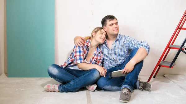 Schönes lächelndes Paar umarmt sich in neuem Haus im Bau — Stockfoto