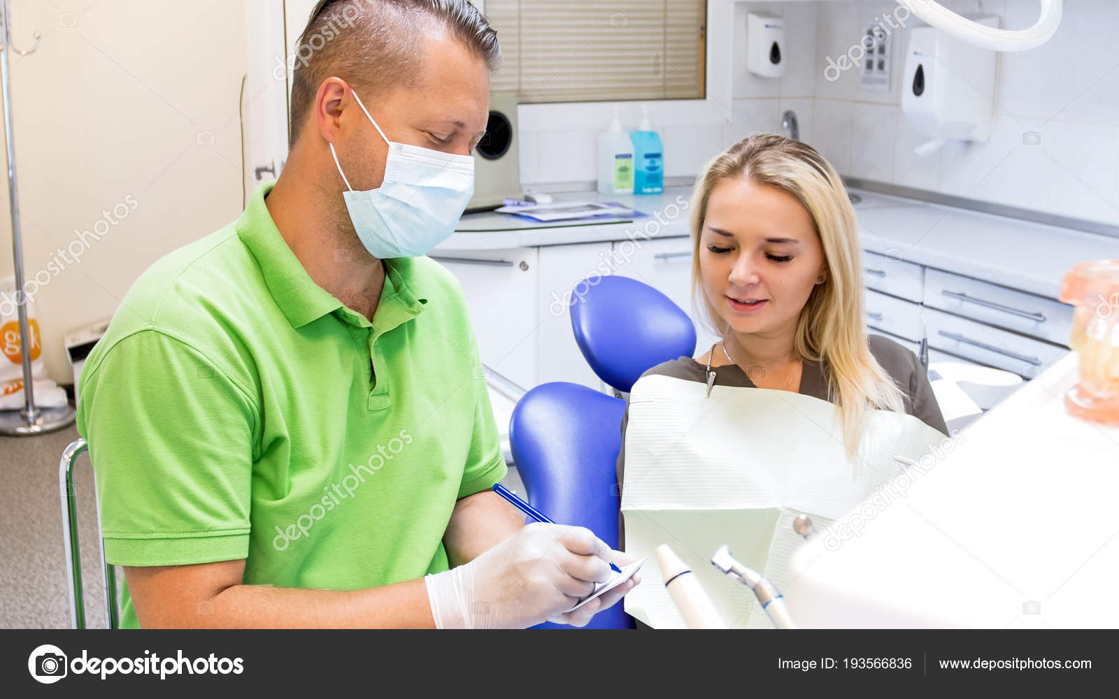 Portrait of male dentist writing prescription to his woman patient