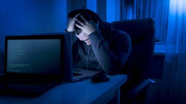 Dizüstü bilgisayarda çalışma geç gece üzgün ve yorgun genç programcı