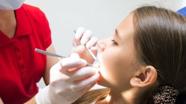 Portre resim bir dişçi lateks eldiven diş muayene için aygıtlar tutan eller