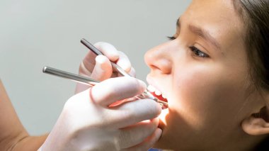 Portre resim bir dişçi aletleri ile kızlar diş teftiş