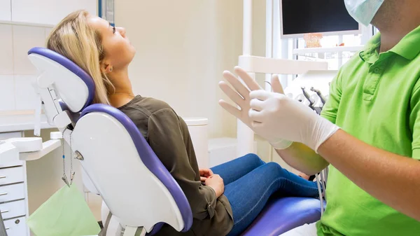 Imagem de close-up do dentista masculino colocando luvas de látex protetoras — Fotografia de Stock