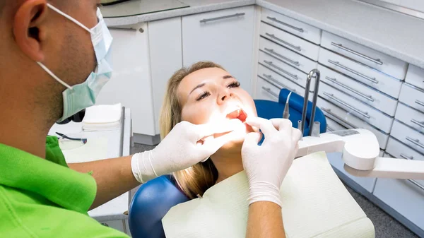 Imagem de perto do dentista verificando os dentes da mulher — Fotografia de Stock