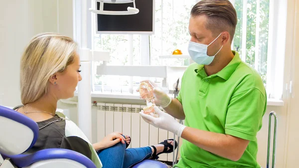 Mannelijke tandarts praat met zijn geduld en een uitleg van de methoden van behandeling — Stockfoto