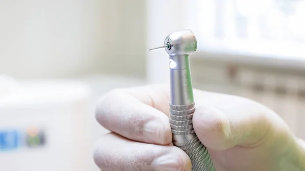 Macro imagen de la mano del dentista en guante de látex sosteniendo taladro dental —  Fotos de Stock