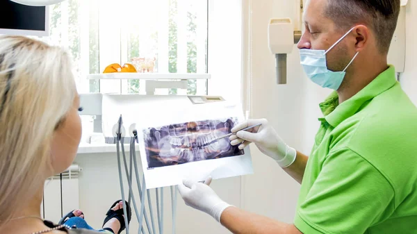 Porträtt av tandläkare visar röntgenbilden till hans kvinnliga tålmodig — Stockfoto