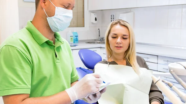 Imagem de perto do dentista escrevendo prescrição para seu paciente — Fotografia de Stock
