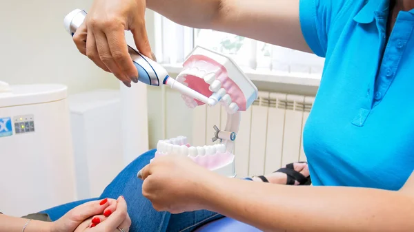 Közelkép kép fogorvos oktatási beteg elektromos fogkefe fogak tisztítás — Stock Fotó